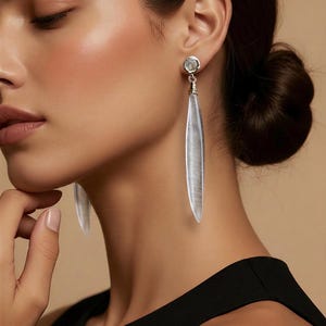 Pendientes de oro con forma de carámbano de cuarzo transparente. Joyas con cierre a presión y gemas de aguja larga.
