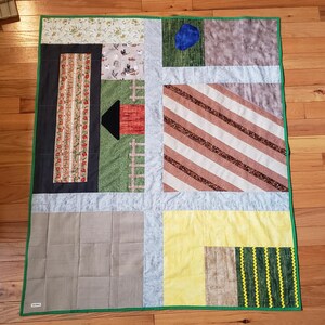 May include: A green, brown, and yellow patchwork quilt with a variety of patterns, including stripes, polka dots, and floral designs.