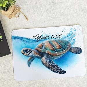 May include: A white mouse mat with a colourful sea turtle swimming in blue water with bubbles. The text "Your text" is printed on the mouse mat.