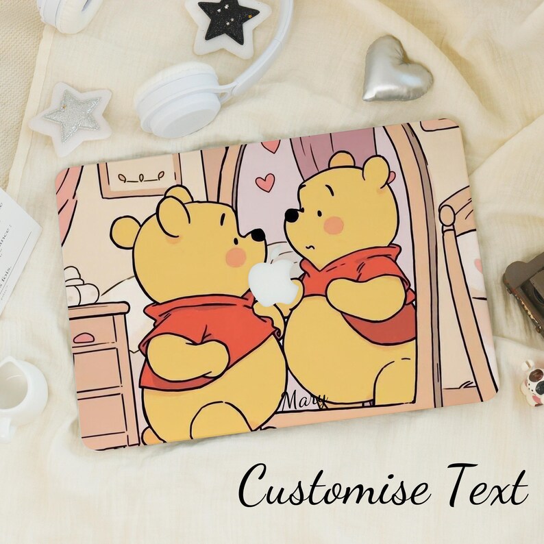 May include: A rectangular laptop skin with a cartoon illustration of two yellow bears in red shirts, holding a white apple. The background is a soft pink room with hearts. The words "Customise Text" are written at the bottom.