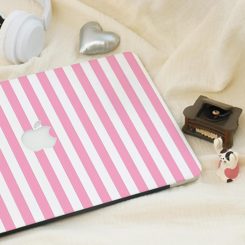 Op de afbeelding: Een roze en witte gestreepte laptop-skin met het Apple-logo in het midden.