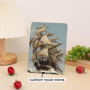 May include: A rectangular decorative panel featuring a vintage painting of a tall ship at sea. The ship has billowing white sails against a blue sky. The text "Lisa" is below the ship, with the words "CUSTOM YOUR NAME" below that.