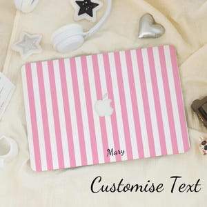 Op de afbeelding: Roze en witte gestreepte laptop skin met een wit Apple-logo en de naam "Mary" gedrukt in de rechterbenedenhoek.  Tekst aanpassen.