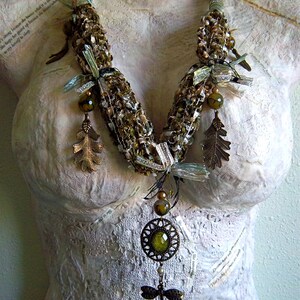 Moss green woven ribbons, yarns, and threads necklace with glass beads, brass charms and green faceted glass pendant statement piece. image 2