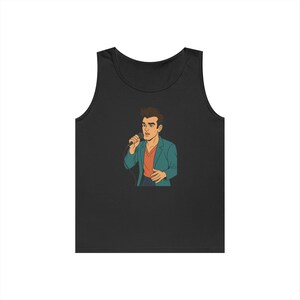 Peut inclure: Débardeur noir avec une illustration de dessin animé d'un homme chantant dans un microphone. L'homme porte un blazer bleu sarcelle sur une chemise orange. L'illustration est de style bande dessinée rétro.