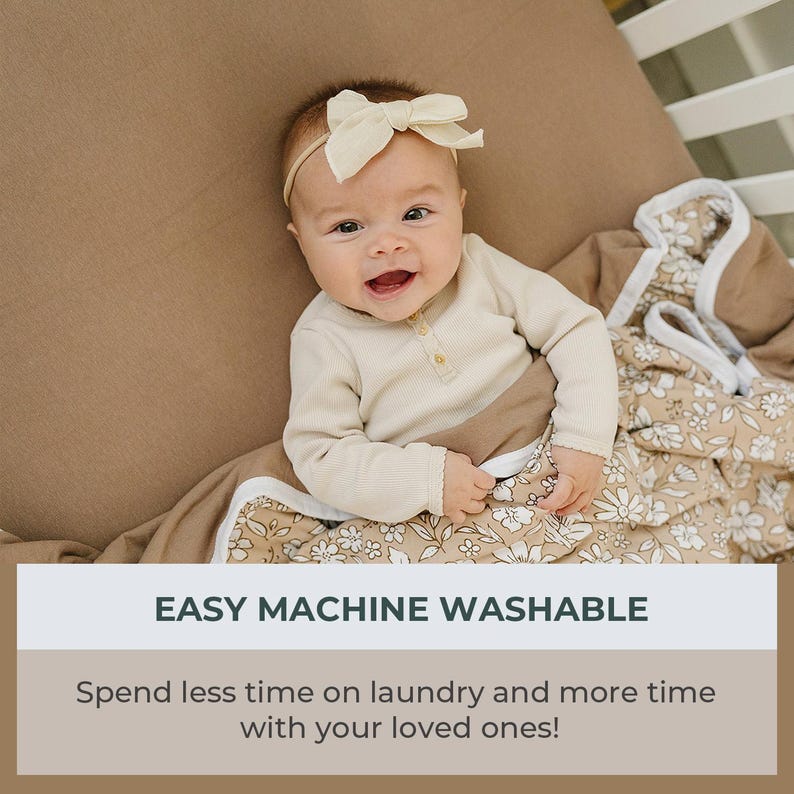 Peut inclure: Un b&eacute;b&eacute; souriant porte un bandeau avec un n&oelig;ud cr&egrave;me et un body beige clair. Le b&eacute;b&eacute; est envelopp&eacute; dans une couverture &agrave; motifs floraux. Le texte "EASY MACHINE WASHABLE" est affich&eacute;, avec la l&eacute;gende "Passez moins de temps &agrave; faire la lessive et plus de temps avec vos proches!"