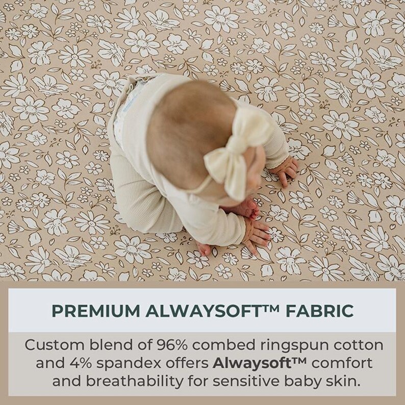 Peut inclure: Un b&eacute;b&eacute; en tenue cr&egrave;me et bandeau &agrave; n&oelig;ud papillon est allong&eacute; sur un tissu beige &agrave; motifs floraux blancs. Le tissu pr&eacute;sente un motif r&eacute;p&eacute;t&eacute; de fleurs et de feuilles blanches. Le texte en bas indique "PREMIUM ALWAYSOFT&trade; FABRIC".