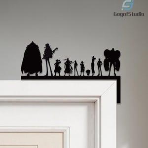 Puede incluir: Silueta negra de un grupo de personajes, probablemente de una serie de anime o manga, montada en un marco de puerta. Las figuras est&aacute;n dispuestas en l&iacute;nea, con diferentes alturas y poses. El texto "GogotStudio" es visible.