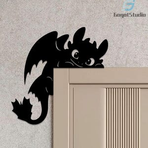 Peut inclure: Décoration murale en métal noir représentant un dragon stylisé. Le dragon a de grandes ailes, une queue incurvée et une expression amicale. Conçu pour être placé dans un coin, il ajoute une touche décorative à n'importe quelle pièce.
