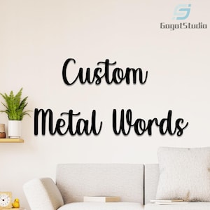 Könnte beinhalten: Ein individuelles Schild aus Metall mit den Worten "Custom Metal Words" in schwarzen Buchstaben auf einer weißen Wand. Das Schild ist aus Metall und hat ein modernes, minimalistisches Design.
