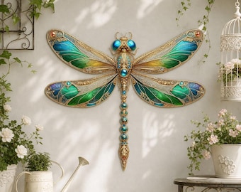 Può includere: Un ornamento decorativo da parete a forma di libellula con ali in filigrana dorata caratterizzate da vivaci sfumature verde ottanio e verde. Il corpo è decorato con piccoli accenti circolari blu e grandi occhi blu in rilievo.