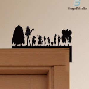 Puede incluir: Silueta negra de un grupo de figuras, posiblemente personajes de un programa o pel&iacute;cula, montada en un marco de puerta. Las figuras est&aacute;n dispuestas en l&iacute;nea, con diferentes alturas y formas. La marca "GagatStudio" es visible.
