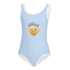 Puede incluir: Traje de baño de una pieza azul claro con ribete blanco. El traje de baño presenta un diseño de concha de dibujos animados con la palabra "SHELLO" encima. La concha es amarilla y naranja con una cara sonriente.