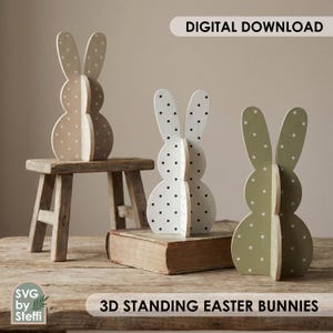 Könnte beinhalten: Drei 3D-Osterhasen-Dekorationen. Einer ist beige mit schwarzen Punkten, einer ist weiß mit schwarzen Punkten und einer ist grün mit weißen Punkten. Der Text "DIGITAL DOWNLOAD" und "3D STANDING EASTER BUNNIES" sind sichtbar.