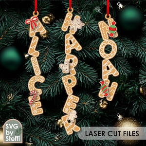 Puede incluir: Adornos navideños de pan de jengibre que deletrean "ALICE", "HAPPY" y "NOAH", colgados de cintas rojas sobre un fondo de árbol de Navidad. Cada letra está decorada con glaseado y detalles festivos. También se ven las palabras "LASER CUT FILES".