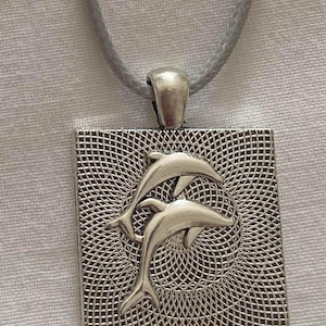 Collier à pendentif dauphin en argent magnifiquement conçu qui aide à protéger les dauphins et à préserver les océans du monde entier.