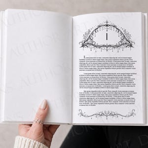 May include: An open book with white pages featuring black printed text and decorative illustrations. The right page displays the number 1 centered within an ornate, arched frame with celestial motifs, followed by paragraphs of placeholder text.