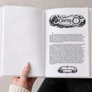 May include: An open book with white pages featuring black ink illustrations. The right page displays a decorative header with the text "CHAPTER 1" surrounded by celestial and fantasy motifs, followed by placeholder text and a bottom border.