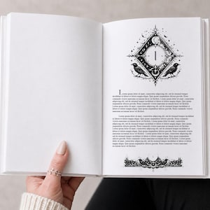 Könnte beinhalten: Ein offenes Buch mit einer detaillierten Schwarz-Weiß-Illustration auf der rechten Seite. Die Illustration zeigt eine Raute mit der Zahl 1 im Inneren, zwei Krähen und Halbmonde. Text ist auf der rechten Seite vorhanden.