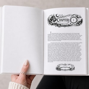 Könnte beinhalten: Ein offenes Buch mit einer dekorativen Schwarz-Weiß-Illustration auf der rechten Seite. Die Illustration zeigt ein Schloss, Mond, Sterne und das Wort "KAPITEL" über der Zahl "1". Die linke Seite ist leer.