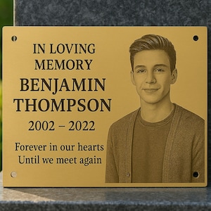 Könnte beinhalten: Goldfarbene Gedenktafel mit dem Text "IN LOVING MEMORY BENJAMIN THOMPSON 2002-2022 Forever in our hearts Until we meet again." Ein Porträt eines jungen Mannes befindet sich auf der rechten Seite der Tafel.