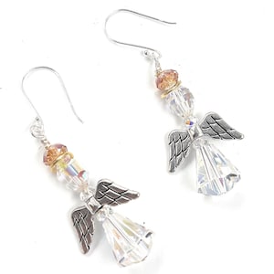 Puede incluir: Un par de pendientes de &aacute;ngel con alas plateadas y cuerpos de cristal transparente facetado. Los pendientes presentan cuentas de cristal iridiscente y ganchos para las orejas plateados. Un accesorio delicado y elegante.