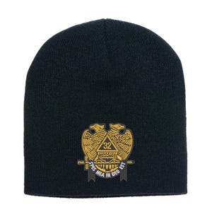 Puede incluir: Un gorro azul marino con un emblema dorado que presenta un águila bicéfala, un triángulo y el número 32. El emblema está centrado en la parte delantera del gorro, con las palabras "SPES MEA IN DEO EST" en una pancarta debajo.