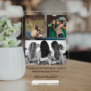 May include: A glass photo frame with a collage of three photos of friends. The bottom photo is in black and white and shows three friends standing together. The top two photos are in color and show the same three friends in different settings. The frame has a quote that reads "True friends are never apart, maybe in distance but never in heart." and the names "Olivia & Charlotte" are printed below the quote.