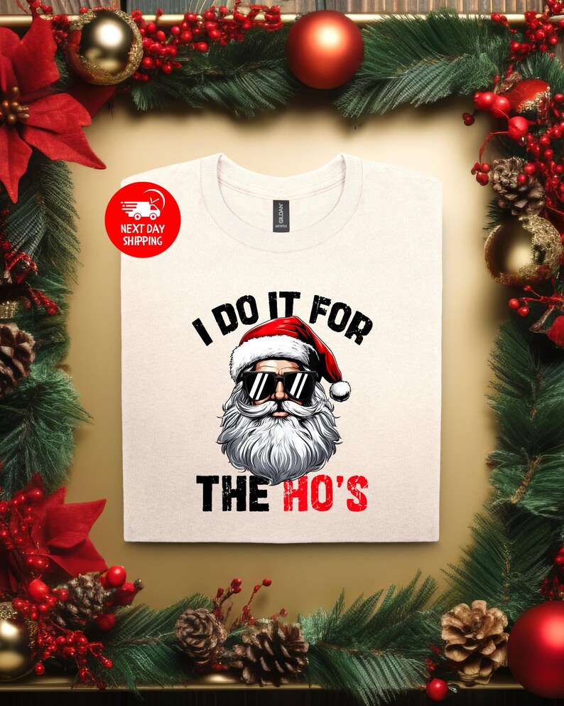 May include: White t-shirt featuring a Santa Claus wearing sunglasses and the text "I do it for the ho's".