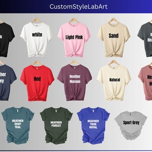 Puede incluir: Una selecci&oacute;n de camisetas en varios colores y estilos, incluyendo negro, blanco, rosa claro, arena, gris oscuro jaspeado, azul marino jaspeado, rojo, granate jaspeado, natural, malva jaspeado, azul oscuro jaspeado, verde bosque jaspeado, azul real jaspeado y gris deportivo.