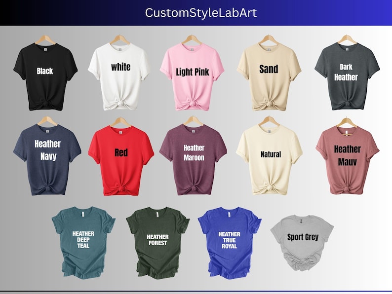 Puede incluir: Una selecci&oacute;n de camisetas en varios colores y estilos, incluyendo negro, blanco, rosa claro, arena, gris oscuro jaspeado, azul marino jaspeado, rojo, granate jaspeado, natural, malva jaspeado, azul oscuro jaspeado, verde bosque jaspeado, azul real jaspeado y gris deportivo.