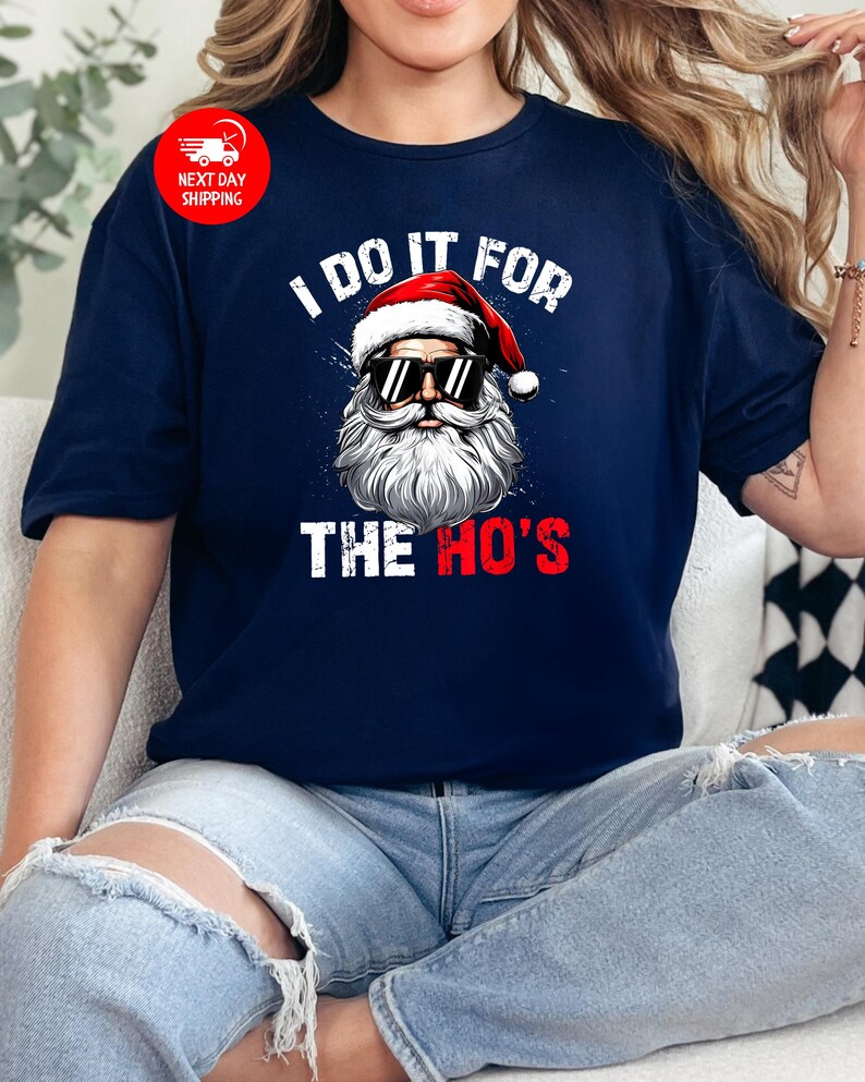 May include: A navy blue t-shirt with a white graphic of Santa Claus wearing sunglasses and the text "I do it for the ho's".