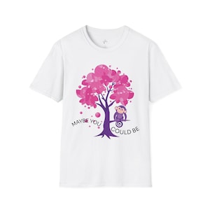 May include: White t-shirt with a graphic of a pink flowering tree and a purple monkey. The text "MAYBE YOU COULD BE" is printed below the tree in dark purple. A fun, whimsical design.