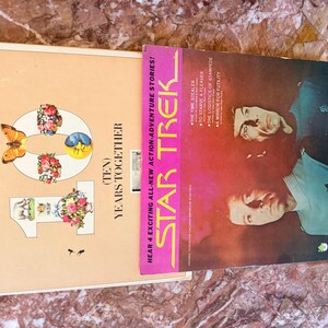 May include: Two vintage record albums. One album cover is beige with a floral design and the text "The Best of Peter, Paul and Mary" and "(Ten) Years Together". The other album cover is red with the text "Star Trek".