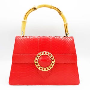 Nuova pochette da donna in vera pelle di pitone rossa con cinturino regolabile.