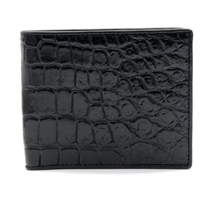 Puede incluir: Una cartera negra de dos pliegues con un patrón de cocodrilo brillante y texturizado. La cartera es rectangular y parece estar hecha de cuero. Los bordes están cuidadosamente cosidos y el diseño general es elegante y moderno.