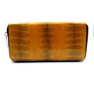 Puede incluir: Un monedero rectangular de color beige con un patrón similar a la piel de reptil. Tiene una cremallera negra y un tirador dorado. El patrón es una mezcla de beige y marrón, creando una apariencia texturizada. El monedero está cerrado.