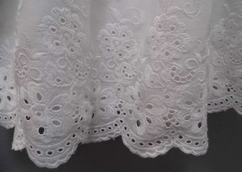 Puede incluir: Tela de algod&oacute;n blanca con un borde festoneado y un delicado patr&oacute;n de bordado floral.