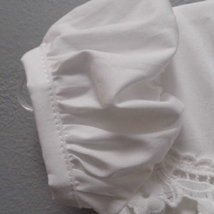 Puede incluir: Blusa blanca de algod&oacute;n con manga abullonada y ribete de encaje.