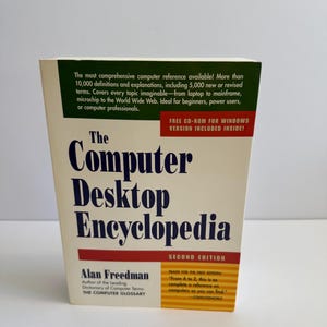 Peut inclure: L'Encyclopédie de l'ordinateur de bureau, deuxième édition, par Alan Freedman. Le livre a une couverture blanche avec le titre en grandes lettres bleues. Le haut du livre contient un texte vert qui se lit comme "La référence informatique la plus complète disponible !"