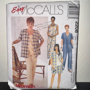 May include: A McCall's sewing pattern envelope featuring illustrations of women's clothing designs. The envelope has the text "Easy McCall's" and "Womanstyle". The designs include a plaid jacket and shorts set, a jumpsuit, and a blue pantsuit.