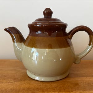 May include: A set of three ceramic mugs with a speckled, matte finish in cream, light grey, and dark grey. Each mug has a simple, minimalist design and a rounded handle. Suitable for coffee or tea.