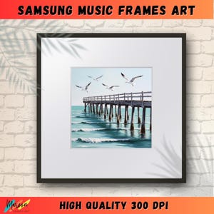 Puede incluir: Una impresión enmarcada de un paisaje marítimo con un muelle de madera que se extiende hacia el océano. El agua es de color azul claro y hay gaviotas blancas volando por encima. La impresión está enmarcada en un marco negro.