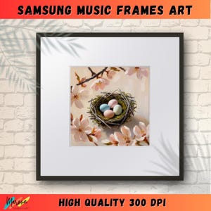 Puede incluir: Una impresión enmarcada de un nido con cuatro huevos de color pastel en un nido de ramitas y musgo. El nido está rodeado de delicadas flores rosas y blancas.