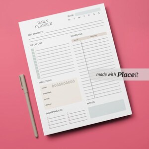 Puede incluir: Un planificador diario blanco con un diseño negro y gris. El planificador incluye secciones para la máxima prioridad, la lista de tareas, el horario, el plan de comidas, la lista de compras y las notas. El planificador también incluye una sección de fecha con los días de la semana abreviados.