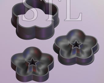 May include: Three black plastic cookie cutters shaped like flowers. The cutters have a star-shaped hole in the center.