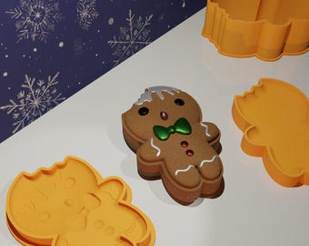 Puede incluir: Un juego de cuatro cortadores de galletas con forma de hombre de jengibre. Los cortadores están hechos de plástico naranja y tienen forma de hombre de jengibre. Los cortadores están sobre una superficie blanca.