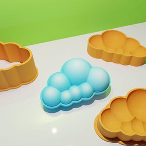 May include: Three silicone molds in the shape of clouds. Two are yellow and one is blue.