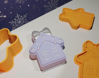 Puede incluir: Un juego de cuatro cortadores de galletas con forma de casa, reno, muñeco de nieve y hombre de jengibre. Los cortadores están hechos de plástico naranja y están listos para hornear galletas de Navidad.