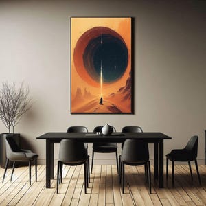 May include: A black and white abstract art print featuring a large circle in the centre. The circle is filled with a dark blue colour and has a white line running through it. The background is a light orange colour. The print is hanging on a wall in a dining room with a black table and chairs.